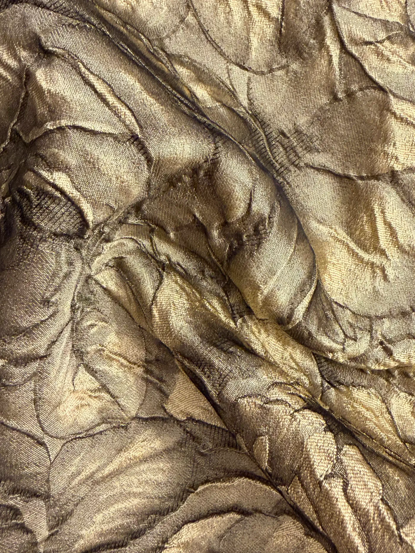 Champagne cloqué, its raised floral surface catching the light, close up
