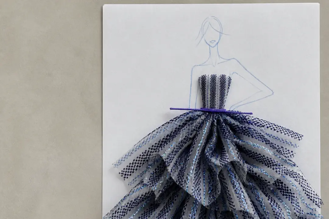 A gown sketch finished with layered navy and silver spotted tulle standing in for the skirt